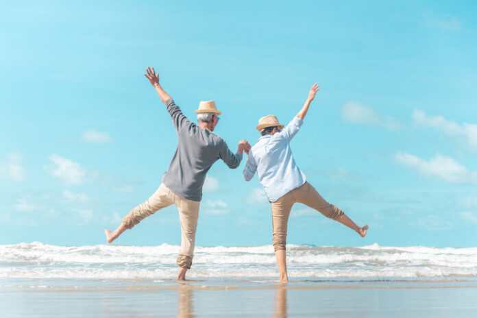 Charming elderly couple went to the beach to enjoy the sea breeze