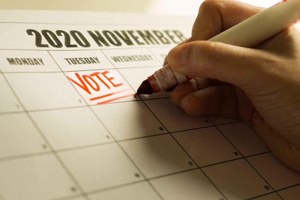 A american voter writing a reminder note on the calender to vote.