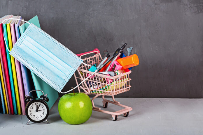Back to School background with grocery cart and medical mask. Collection of school supplies. Education during coronavirus covid-19 pandemic. Copy space, mockup, template. High quality photo