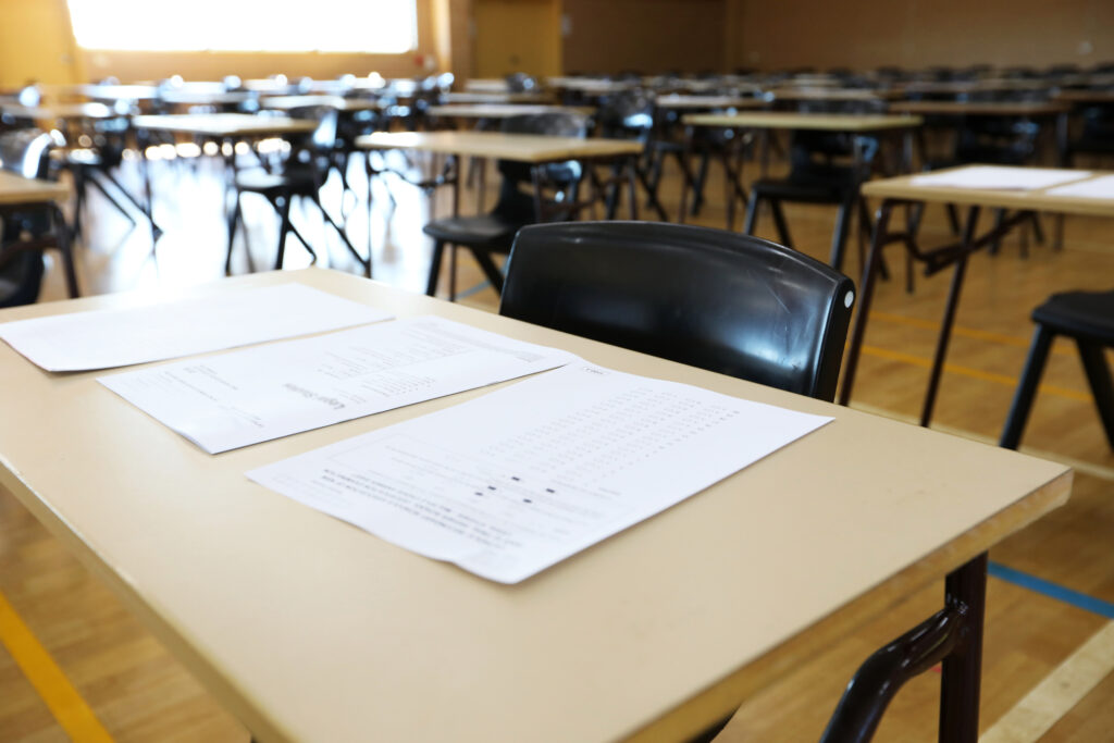 series of views of an examination hall or room images with exam tables set up ready for students. empty chairs and tables. End of school exams university entrance or higher school certificate scene.