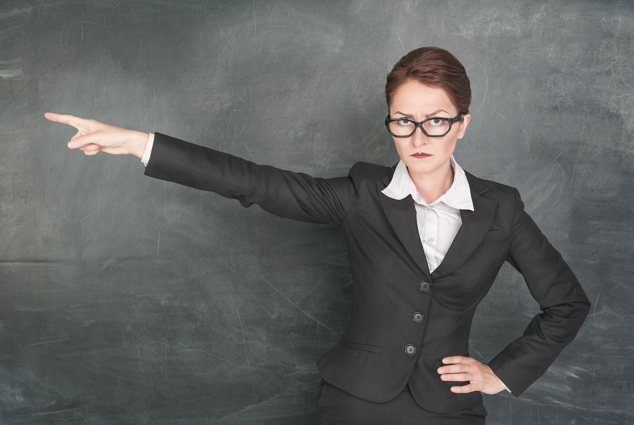 Angry teacher in glasses pointing out