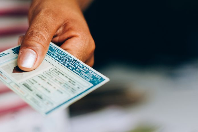 Man holds National Driver's License (CNH). Official document of Brazil, which attests the ability of a citizen to drive land vehicles. Washington.