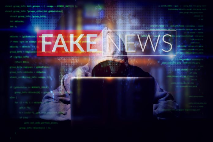 hacker working on a computer laptop, double exposure with screen of fake news. manipulated content on internet . anonymous face
