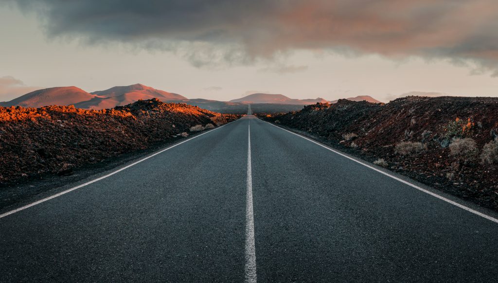 Empty road through the volcanic field at the sunrise with copy space