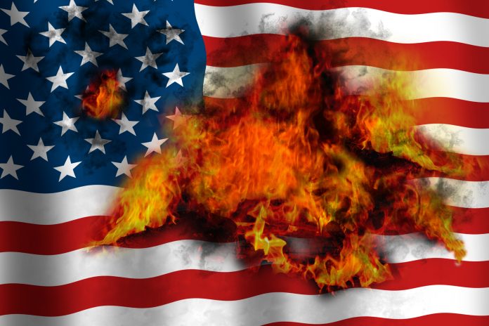 American waving flag in flames burning from inside. Concept image.