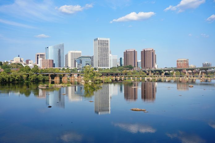 Buildings in downtown Richmond Virginia on a sunny day with blue sky. James River in the foreground