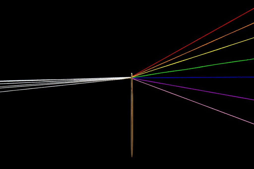 Photo includes Pink Floyd prism made ​​of threads and needle. In the left side the thread is white and in right side the threads are the colors of the rainbow.