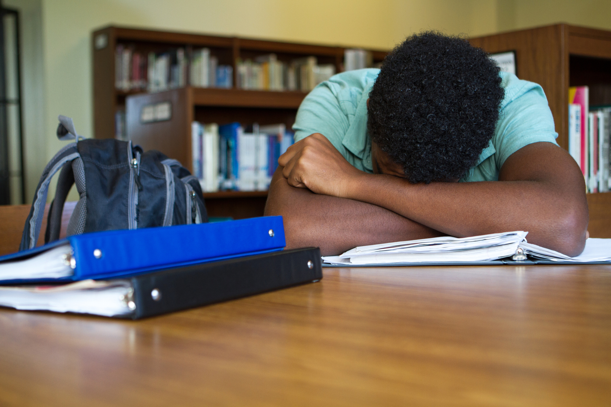 African American student overwhelmed with homework, learning loss