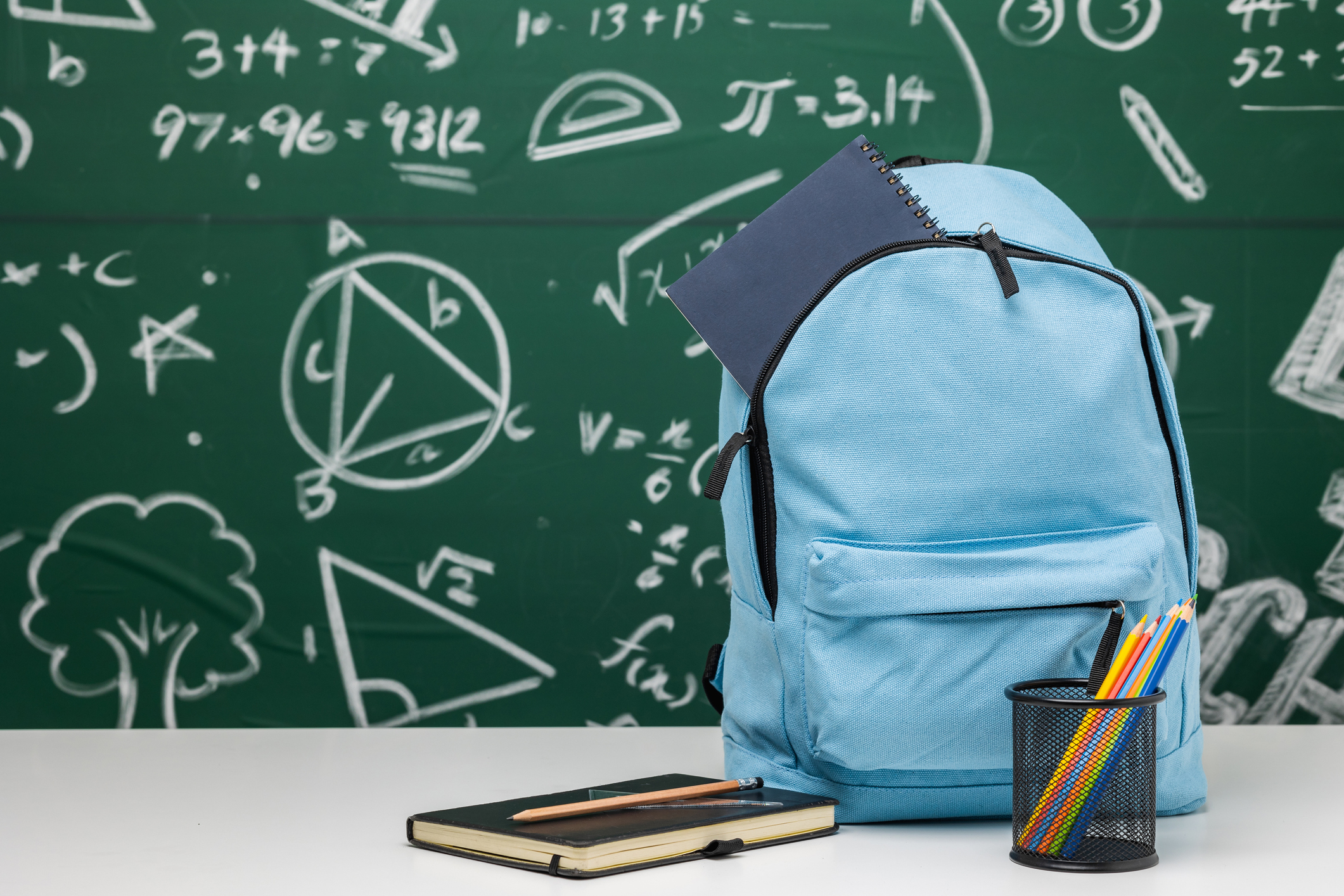 Back to school background. Stationery Supplies in the school bag. Banner design education On chalkboard with the Mathematical formula.