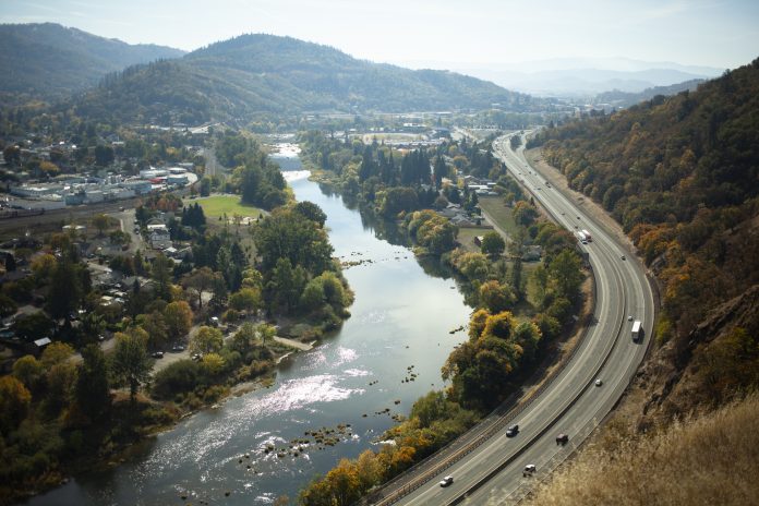 A view from Mt. Nebo in Roseburg, OR, USA looking down on the valley and the small town. The freeway follows the river bend with Autumn colors.